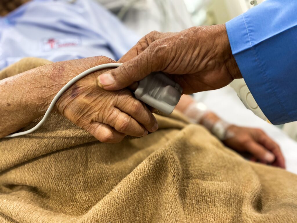 A hand reaching out holding a patient's hand