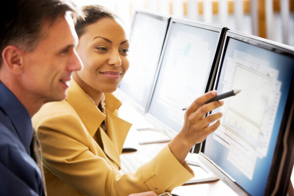 Two colleagues look at a computer screen