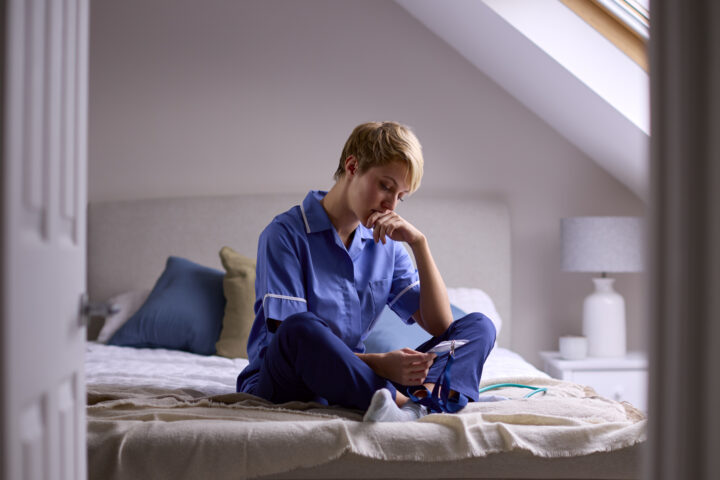 Photo of a woman in scrubs looking thoughtful