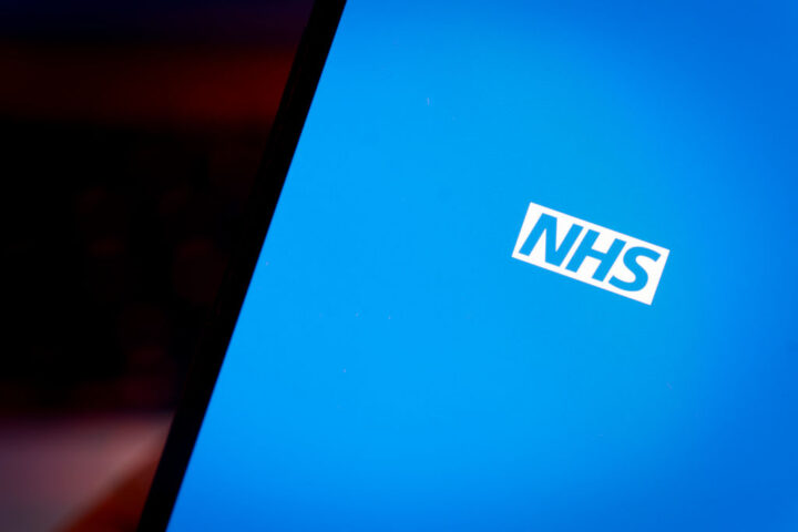 A blue screen with the NHS logo in the centre